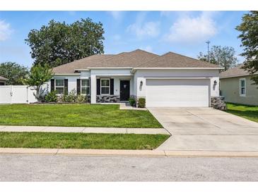 Charming single-story home with a well-manicured lawn and two car garage at 15411 Taurus Ct, Mascotte, FL 34753