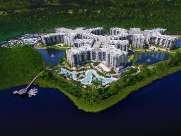 Stunning aerial view of resort-style condos with pools, lakes, and a pier at 15695 Grove Resort Ave # 4438, Winter Garden, FL 34787