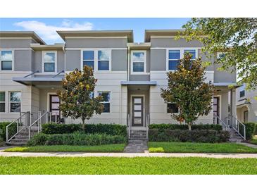 Charming gray and white townhome featuring a manicured lawn and inviting front entrance at 15946 Marina Bay Dr, Winter Garden, FL 34787