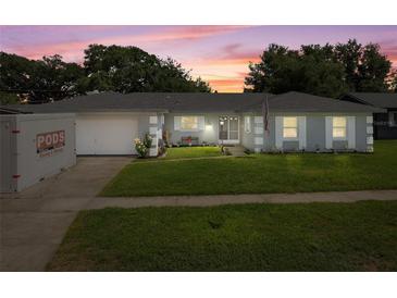 Charming single-story home with a well-manicured lawn and inviting facade at sunset at 217 Spencer St, Orlando, FL 32839