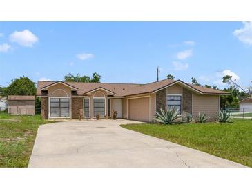 Traditional single-story home with brick accents, attached garage, and a large driveway at 2880 Trenton Ln, Deltona, FL 32738