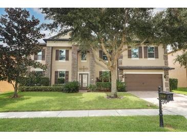 Charming two-story home with a well-manicured lawn, mature trees, and a two-car garage at 319 Morning View Dr, Winter Garden, FL 34787