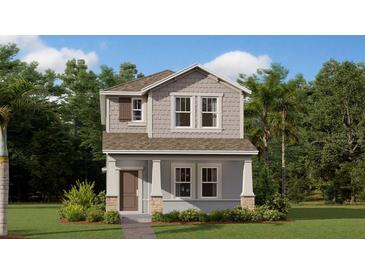 Charming two-story home featuring a covered porch, gray siding and manicured landscaping at 5984 Zen Way, Clermont, FL 34714