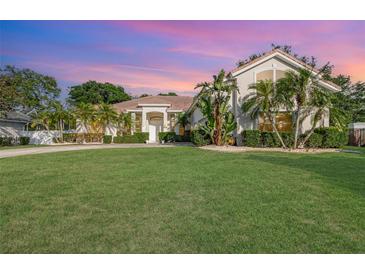 Charming home features a lush lawn, tropical landscaping, and a welcoming entrance at 6121 Oxbow Bend Ln, Port Orange, FL 32128