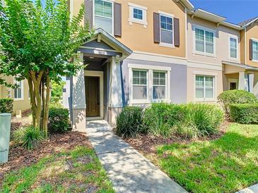 Inviting townhouse featuring a covered entryway, manicured landscaping, and a welcoming facade at 7508 Bentonshire Ave, Windermere, FL 34786