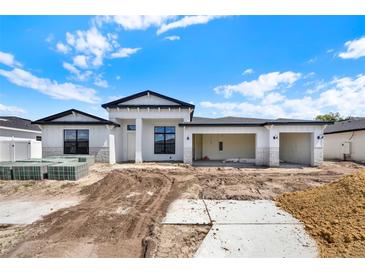 New construction featuring a white exterior, black roof, and open three car garage at 9241 Eagles Perch Pl, Orlando, FL 32825