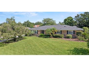 Charming brick home featuring a well-manicured lawn and mature landscaping at 1271 Old Mill Rd, Orlando, FL 32806