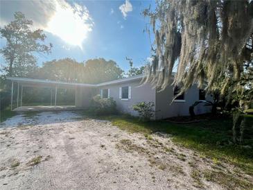 Charming single-story home with a carport and a gravel driveway, offering a blend of comfort and convenience at 212 Homewood Dr, Sanford, FL 32773