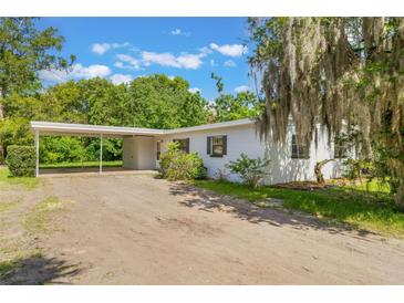 Charming single-story home features a carport and a spacious yard, offering comfort and convenience in a serene setting at 212 Homewood Dr, Sanford, FL 32773