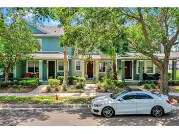 Charming multi-colored townhomes featuring lush landscaping and a neatly paved walkway at 8445 Leeland Archer Blvd, Orlando, FL 32836