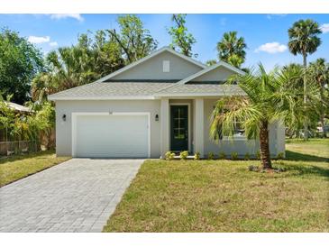 Charming single-story home with a well-manicured lawn, paved driveway, and attached garage at 1119 W 7Th St, Sanford, FL 32771