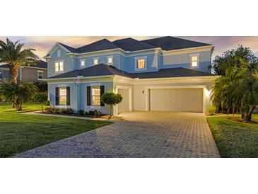 Two-story home featuring a driveway, lawn and a three-car garage at 16086 Johns Lake Overlook Dr, Winter Garden, FL 34787