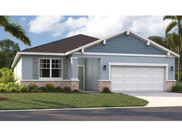 Charming single-story home featuring a two-car garage, stone accents, and neatly landscaped front yard at 3569 Dahlia Dr, Lake Hamilton, FL 33851