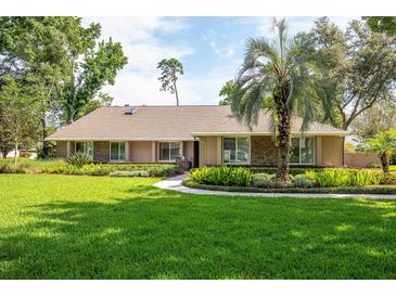 Charming one-story home featuring a well-manicured lawn and lush landscaping at 1600 N Wind Ct, Winter Springs, FL 32708