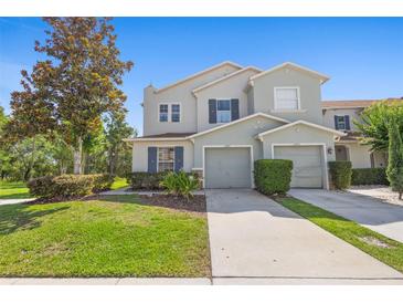 Charming townhome featuring a two-car garage, well-manicured lawn, and inviting curb appeal at 2488 Hassonite St, Kissimmee, FL 34744