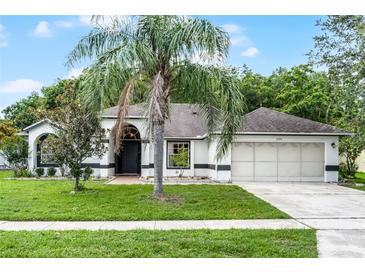 Charming single-story home featuring a well-manicured lawn, mature landscaping, and a two-car garage at 2888 Middleton Cir, Kissimmee, FL 34743