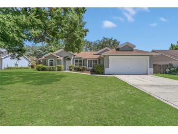 Charming single-story home with a well-manicured lawn and two-car garage at 3014 Linmont Ln, Eustis, FL 32726