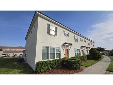 Two-story townhome with manicured shrubs and landscaping at 3128 Camino Real N Dr, Kissimmee, FL 34744
