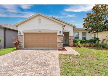 Charming single-story home featuring a brick driveway, a two car garage and meticulously landscaped yard at 3953 Baja Dr, St Cloud, FL 34772