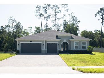 Beautiful home featuring a three car garage and a well-manicured lawn at 5161 Kingwell Cir, Oviedo, FL 32765