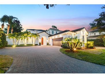 Beautiful home with a herringbone brick drive, lush landscaping, and an attached garage at 9743 Covent Garden Dr, Orlando, FL 32827