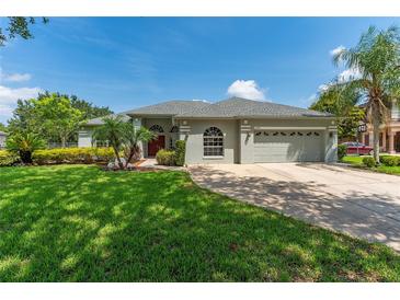 Charming single-story home featuring a well-manicured lawn, beautiful landscaping, and a two-car garage at 13108 Lakeshore Grove Dr, Winter Garden, FL 34787