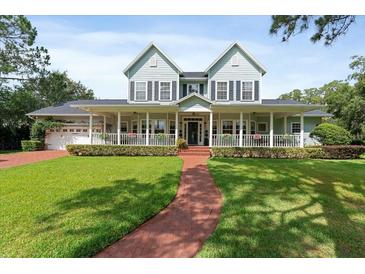 Charming two-story home boasts a large front porch, green lawn, and beautiful curb appeal at 1550 Bluewater Run, Chuluota, FL 32766