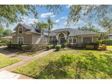 Charming home featuring mature trees, lush green lawn, and manicured shrubs at 2046 Westover Reserve Blvd, Windermere, FL 34786