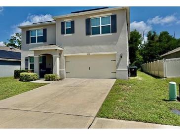 Charming two-story home with a well-maintained lawn and attached two-car garage at 6780 Coral Berry Dr, Mount Dora, FL 32757
