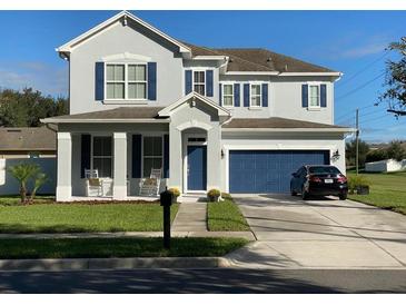 Charming two-story home featuring a manicured lawn, rocking-chair porch, and attached two-car garage at 7561 Colbury Ave, Windermere, FL 34786