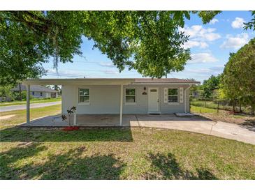 Charming single-story home features a covered front porch, white door and windows, and a well-maintained lawn at 7701 Cassino Ave, Orlando, FL 32819