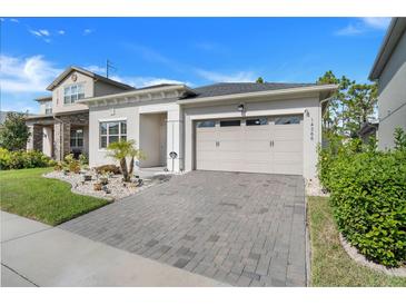 Well-maintained single Gathering home with a brick paver driveway and beautiful landscaping at 14366 Alafaya Oak Bnd, Orlando, FL 32828