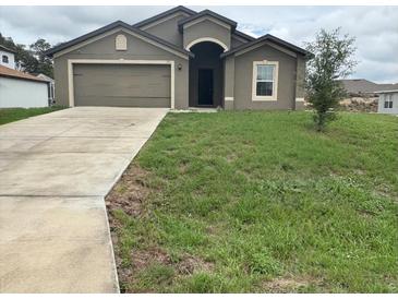Charming one-story home featuring a two car garage, neutral stucco and a well-maintained front lawn at 1713 Redfin Way, Kissimmee, FL 34759