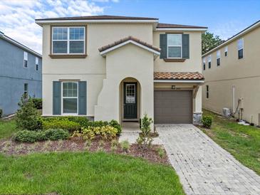 Charming two-story home featuring a well-maintained yard, neutral paint, and an attached one-car garage at 1999 Tropical Palms Cir, Kissimmee, FL 34747