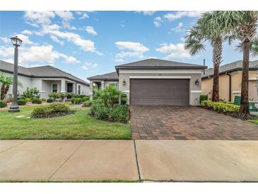 Charming one story home featuring a paved driveway, two-car garage, and beautifully landscaped front yard at 2342 Clemblue Rd, Clermont, FL 34715