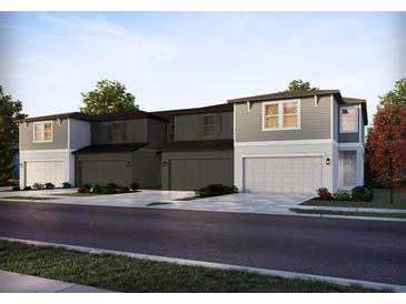 New construction townhomes featuring an attached garage and a combination of gray siding and white trim at 4297 Ranch House Rd, St Cloud, FL 34772