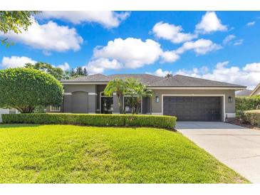 Charming single-story home features a well-manicured lawn, trimmed hedges, and a two-car garage at 5335 Bay Side Dr, Orlando, FL 32819