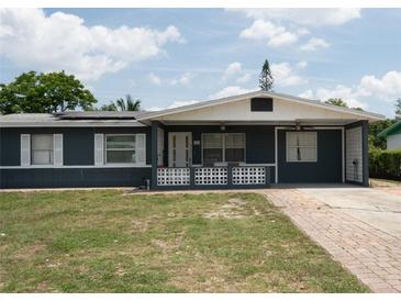 Charming single-story home featuring a blue exterior, brick accents, and a well-maintained lawn and driveway at 5723 Harcourt Ave, Orlando, FL 32810