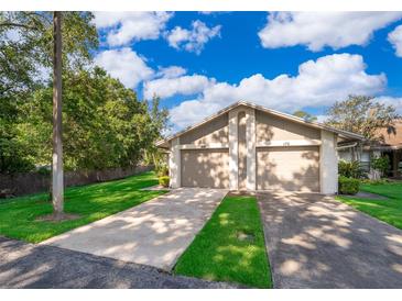 Two-car garage with well-manicured lawn and lush landscaping at 168 Hill St, Casselberry, FL 32707