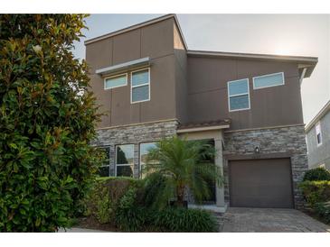 Contemporary two-story home with stone accents, neutral siding, and mature landscaping at 1836 Sandy Park Trl, Kissimmee, FL 34747