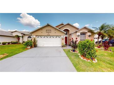 Charming one-story home with well-manicured lawn, mature landscaping, and a two-car garage at 2506 Shelby Cir, Kissimmee, FL 34743