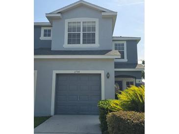 Two-story home showing garage, updated landscaping, and modern paint scheme at 1754 Fritwell Ct, Ocoee, FL 34761