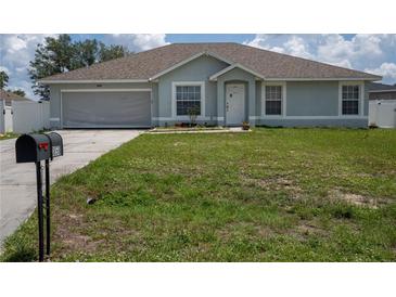 Charming single-story home featuring a well-maintained lawn, attached garage, and welcoming front entrance at 1858 Snapper Dr, Poinciana, FL 34759
