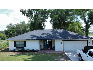 Charming single-story home featuring a well-manicured lawn, brick entrance, and attached garage at 6428 Lynn Rd, Orlando, FL 32810