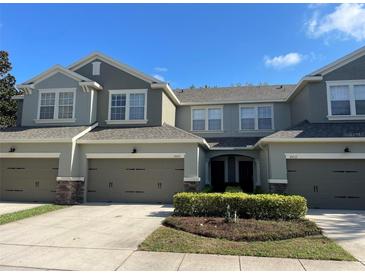 Charming townhome with a well-maintained lawn, two car garage, and neutral gray color scheme at 8608 Falstaff Pl, Oviedo, FL 32765