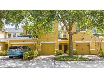 Inviting townhome with a warm yellow exterior, featuring well-maintained landscaping and attached garages at 14231 Desert Haven St # Ge, Windermere, FL 34786