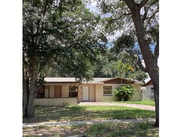 Traditional single-story home featuring a well-manicured front yard with a brick-paved driveway and mature landscaping at 2023 Messina Ave, Orlando, FL 32811