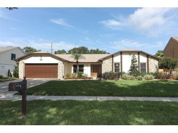 Charming single-story home with a well-manicured lawn, stone accents, and a two-car garage at 414 Bonifay Ave, Orlando, FL 32825