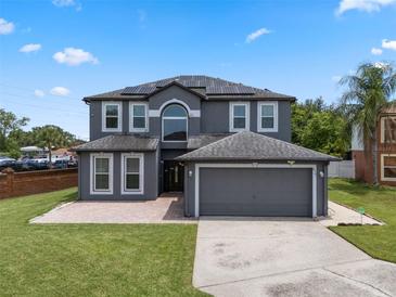 Beautiful two-story home with a spacious driveway, solar panels, and well-maintained landscaping at 470 Regal Downs Cir, Winter Garden, FL 34787