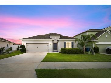 Charming single-story home boasts a two-car garage and well-manicured lawn under a picturesque sky at 622 Taft Dr, Davenport, FL 33837